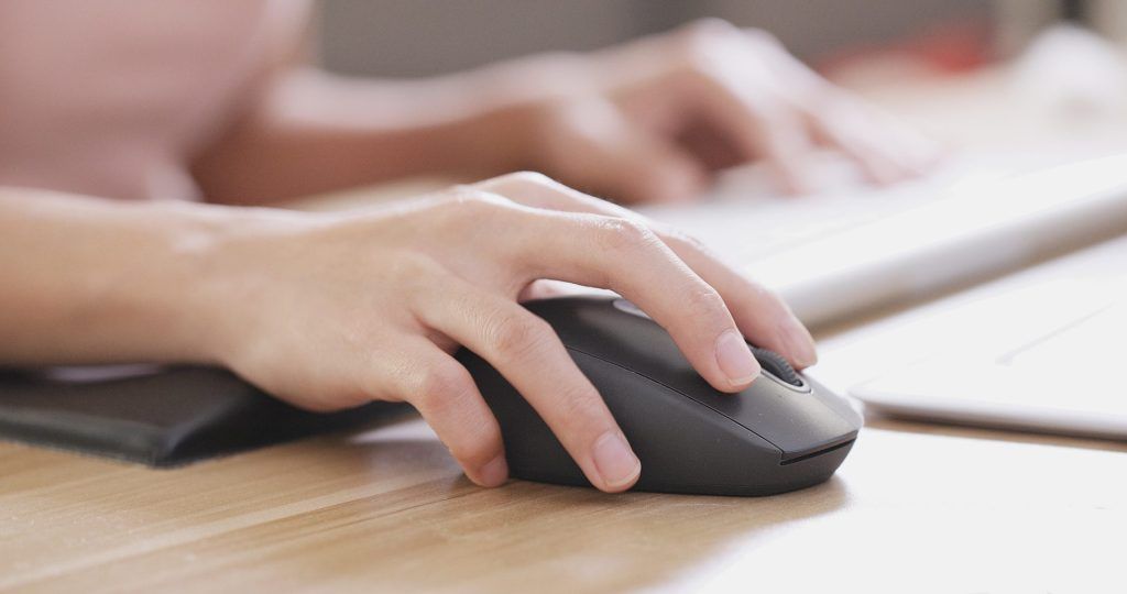Mão segurando o mouse e clicando para iniciar a automação contábil em home office