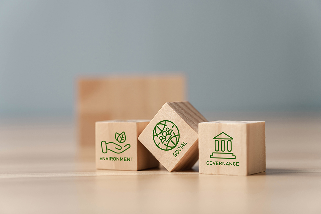 Cubos de madeira sobre uma mesa representando os critérios de ESG.