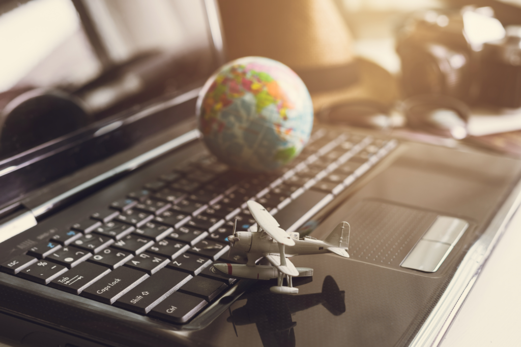 Um avião e um globo terrestre em cima de um notebook representando o global business services.